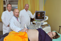 Prof. Deniz Kececioglu (r.), Dr. Johannes Steinhard (m.) und Dr. Kai Thorsten Laser (l.) bei der ersten Ultraschalluntersuchung der Patientin Janina Fahlbusch.