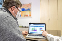 Der Arzt bespricht mit dem Patienten seinen mittels der Aufzeichnungen des Vivior-Monitors erstellten individuellen Sichtbericht .
